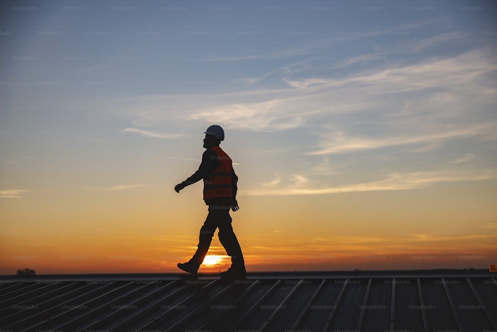 A constructor walking on the roof.