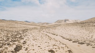 砂丘と砂漠があり、明るい空と山々が風景に浮かぶ美しい風光明媚な旅行先。地球温暖化のための砂漠化と気候変動の概念。
