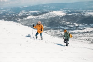 Young hiking couple ascending mountain in the winter.