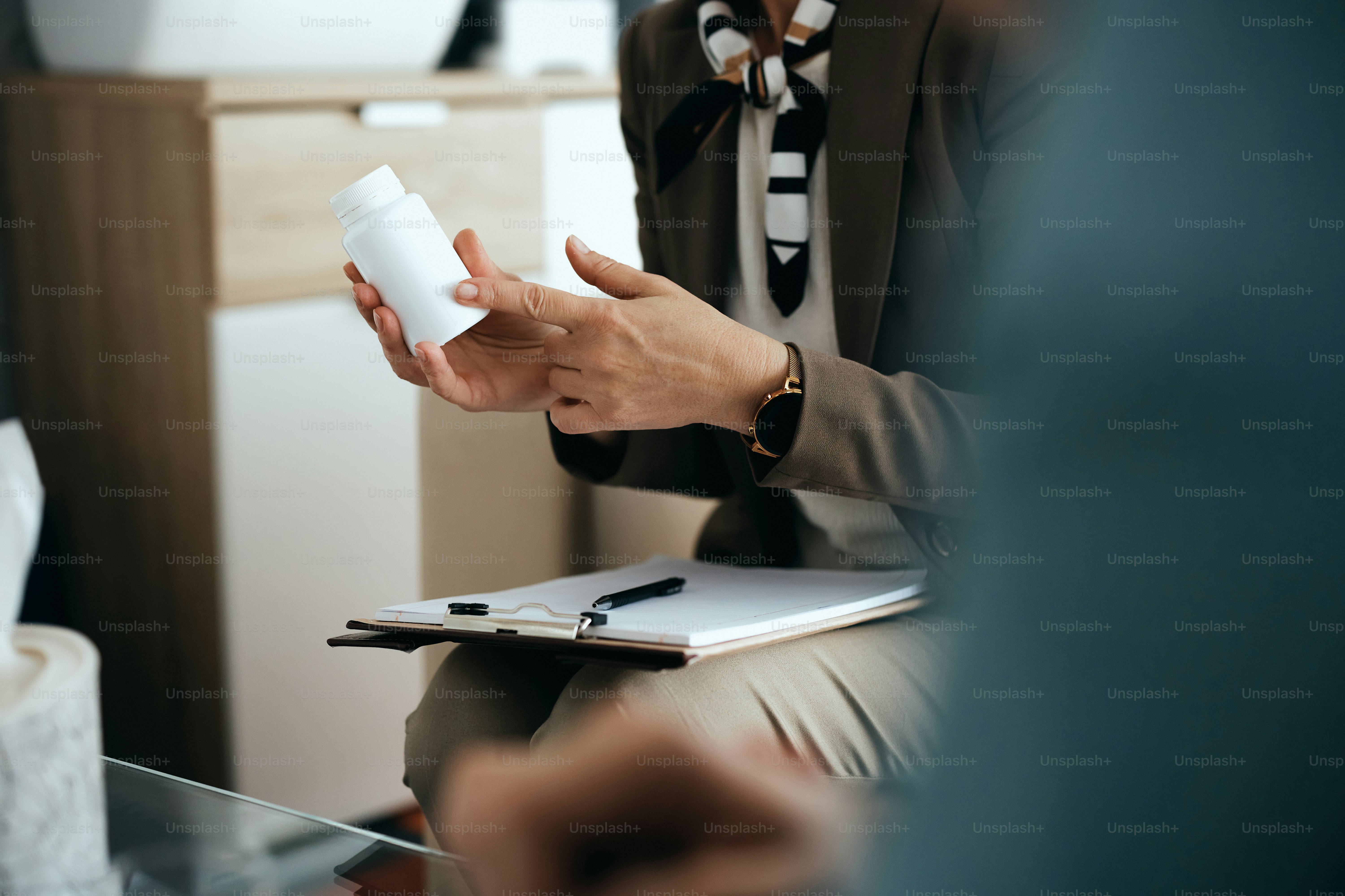 Closeup of psychiatrist giving prescription pills to her patient during a meeting at mental