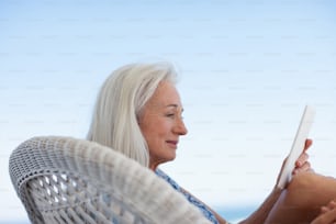 a woman sitting in a chair reading a book