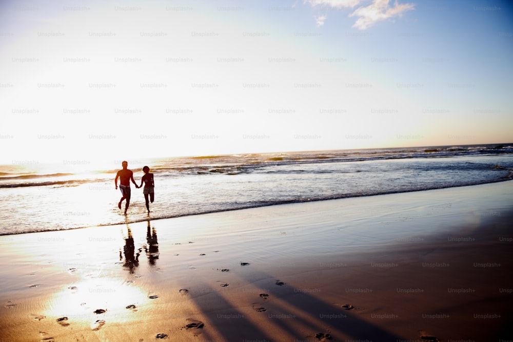Un couple de personnes qui marchent sur une plage
