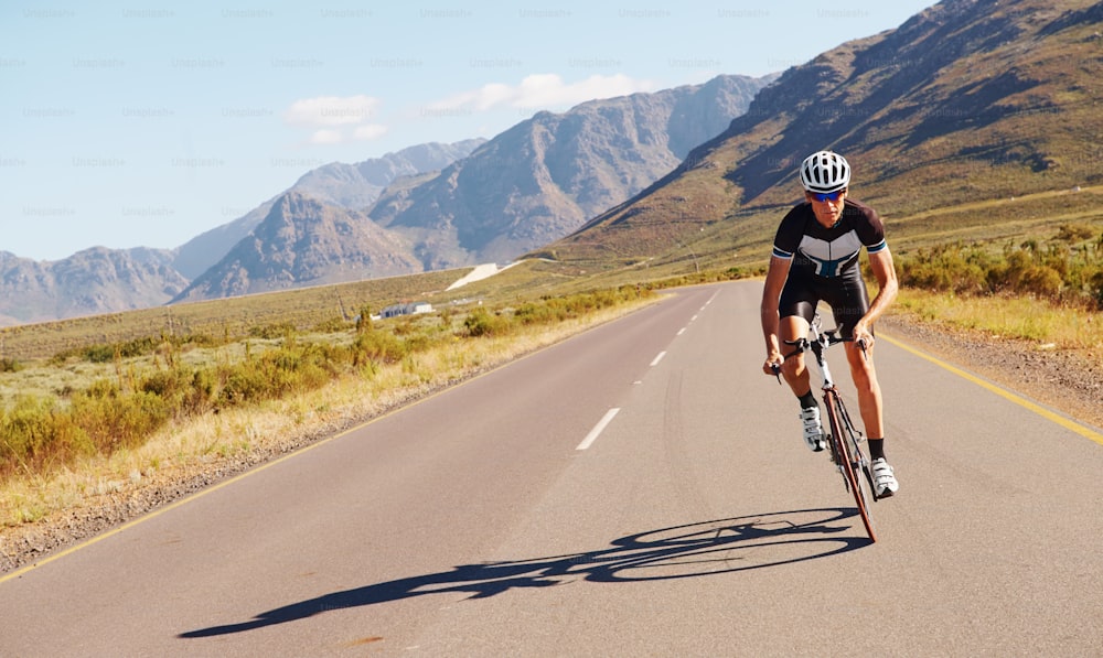 Shot of a lone cylist riding down a scenic country road