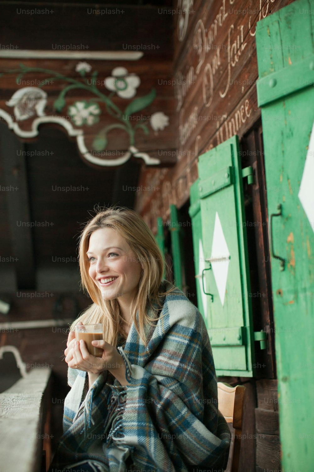 a woman sitting on a bench holding a cup of coffee