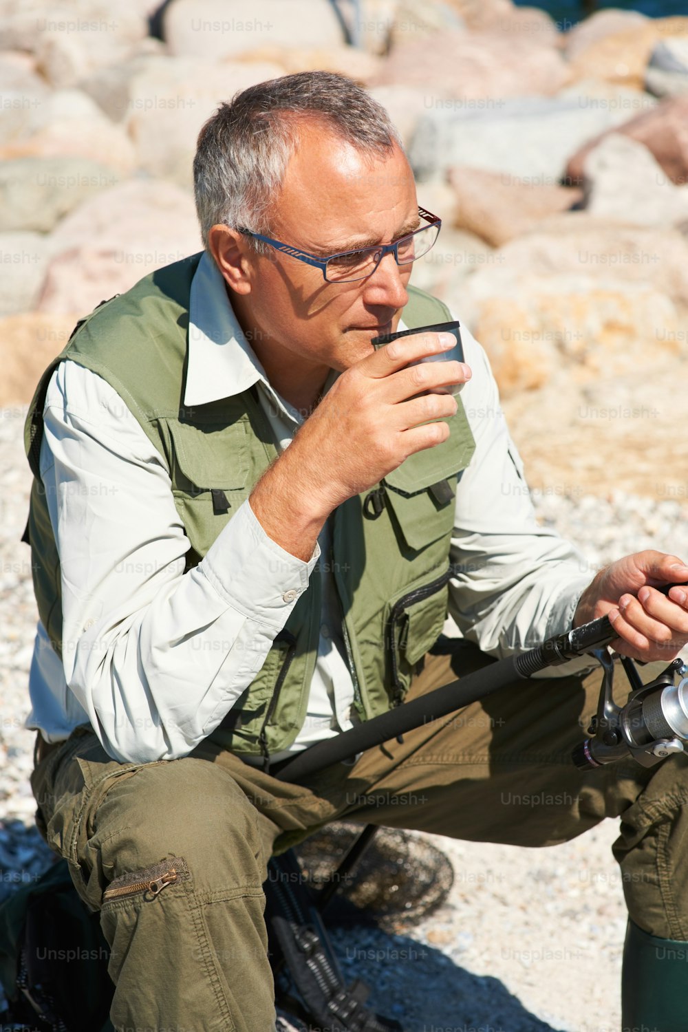 a man sitting on the ground holding a camera