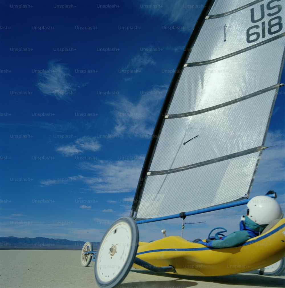 a small sailboat on the beach with a person in it