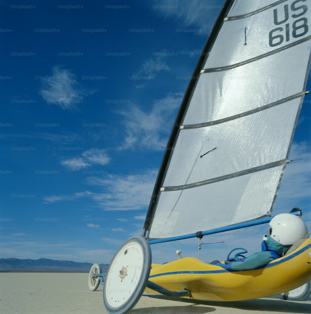 a small sailboat on the beach with a person in it