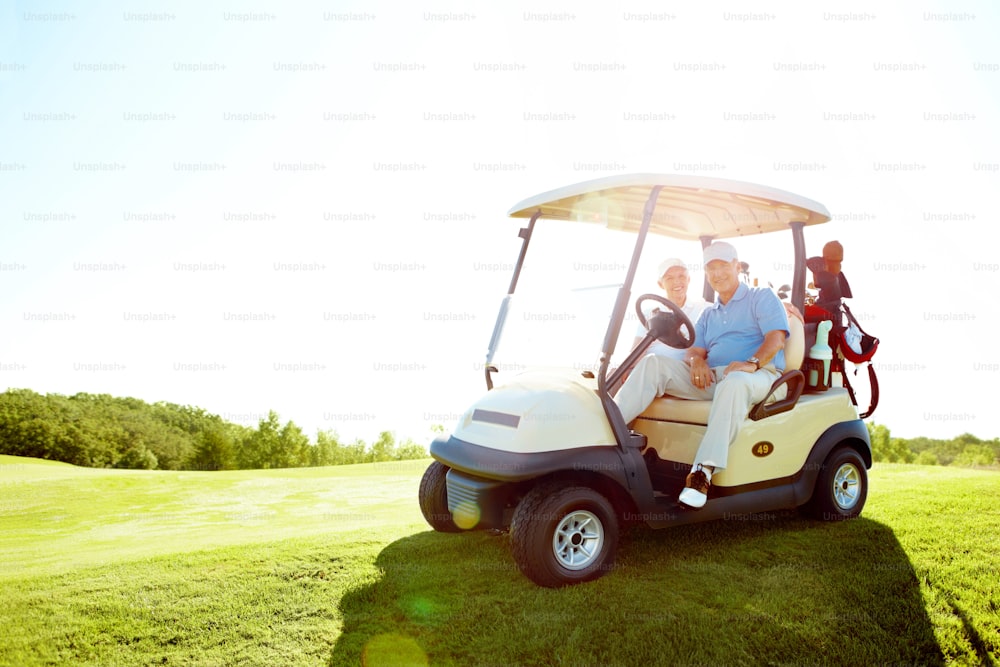 Portrait of a senior retired couple drivig a golf cart on a golf course