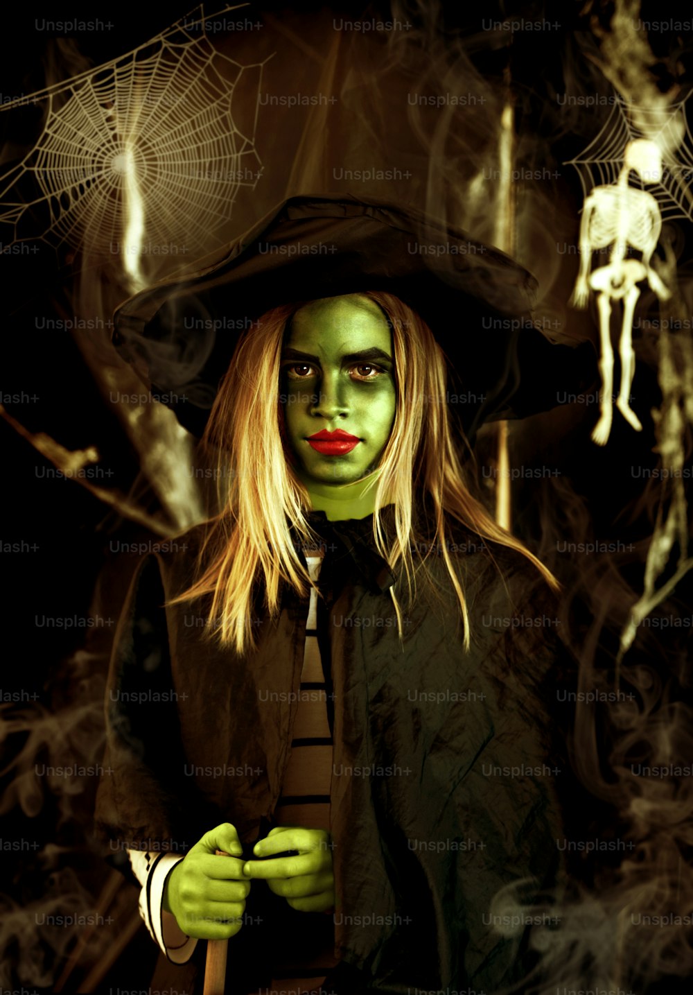 a woman dressed as a witch with green makeup