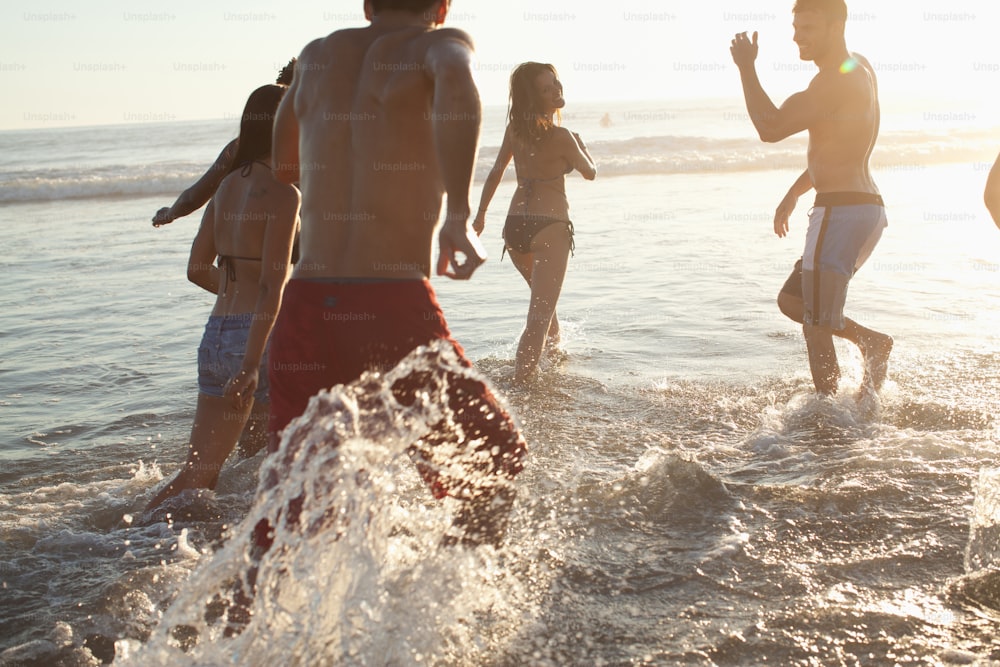 Un grupo de personas de pie en el agua en la playa