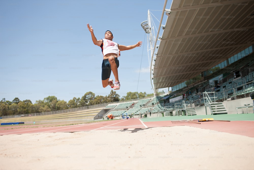 Ein Mann springt auf einer Strecke in die Luft