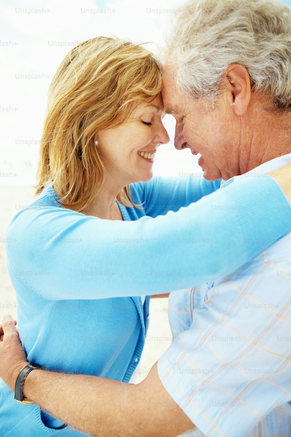 A senior couple standing face to face on the beach