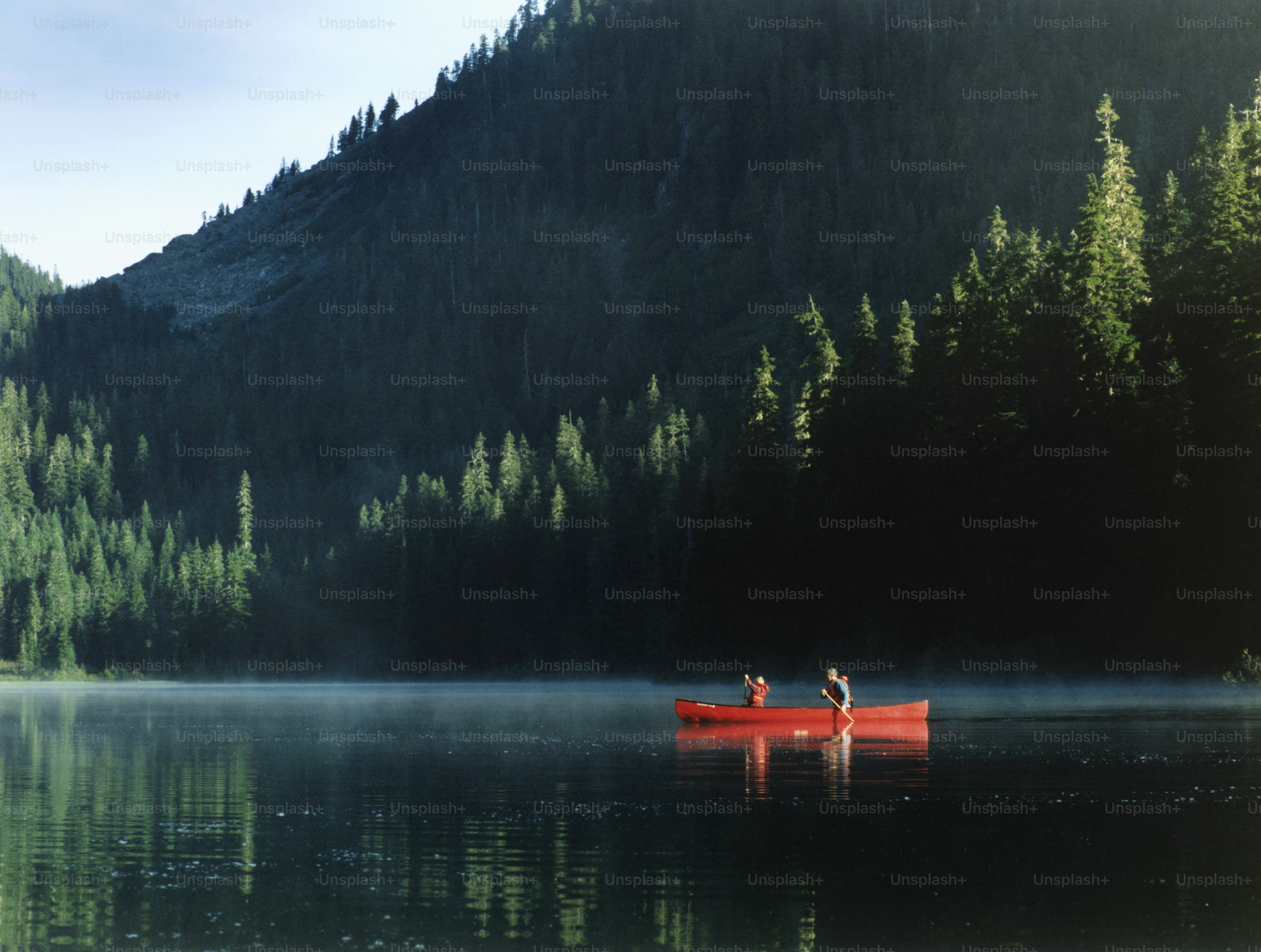 kayakiste sur le lac Moraine avec montagnes en arrière plan.
