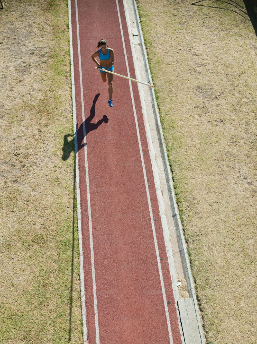 Um homem está correndo em uma pista vermelha