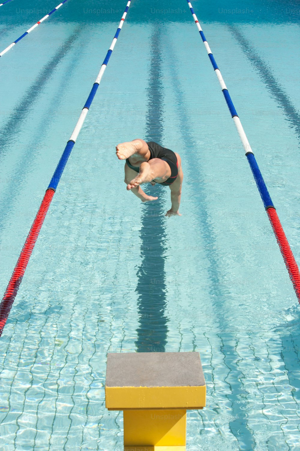 Un homme plongeant dans une piscine