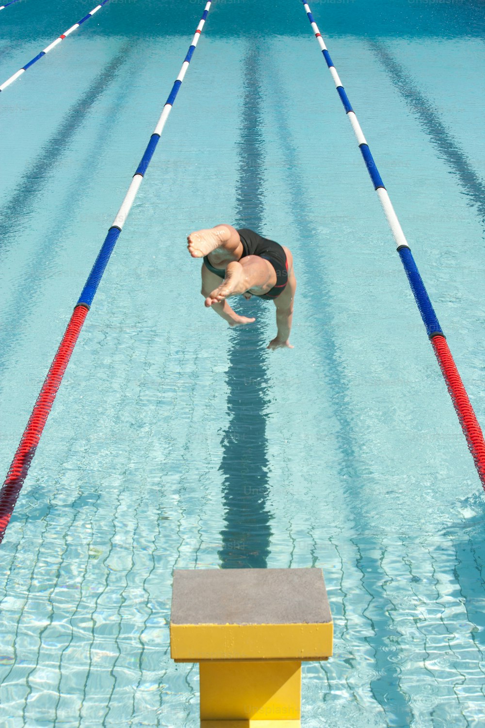 a man diving into a swimming pool