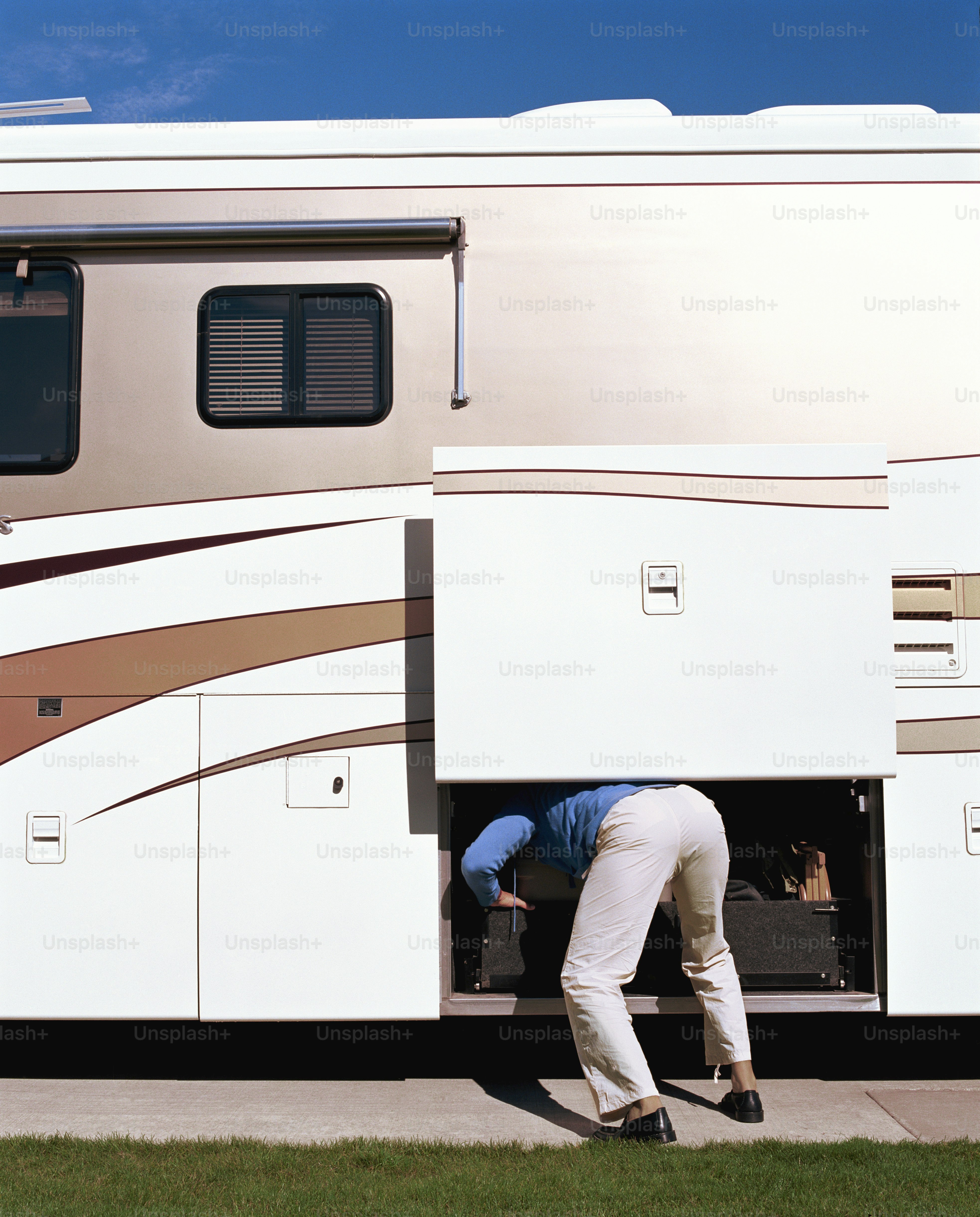 a man is putting something in the back of a recreational vehicle