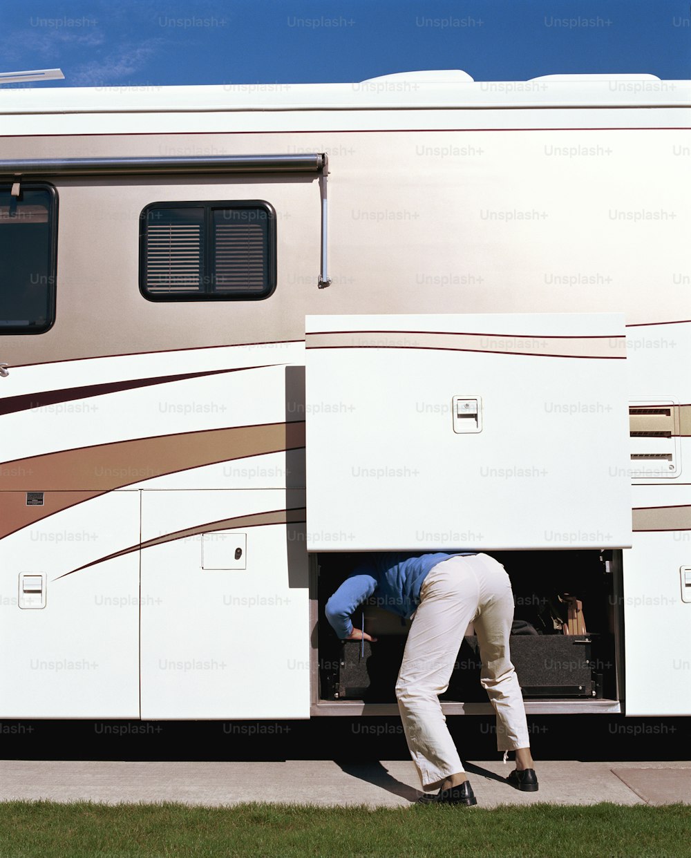 a man is putting something in the back of a recreational vehicle