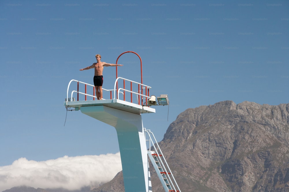 a man standing on top of a life guard tower