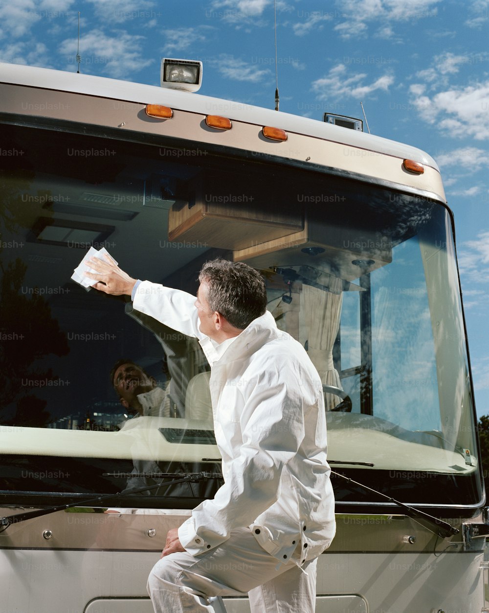 a man in a white shirt is sitting on a bus