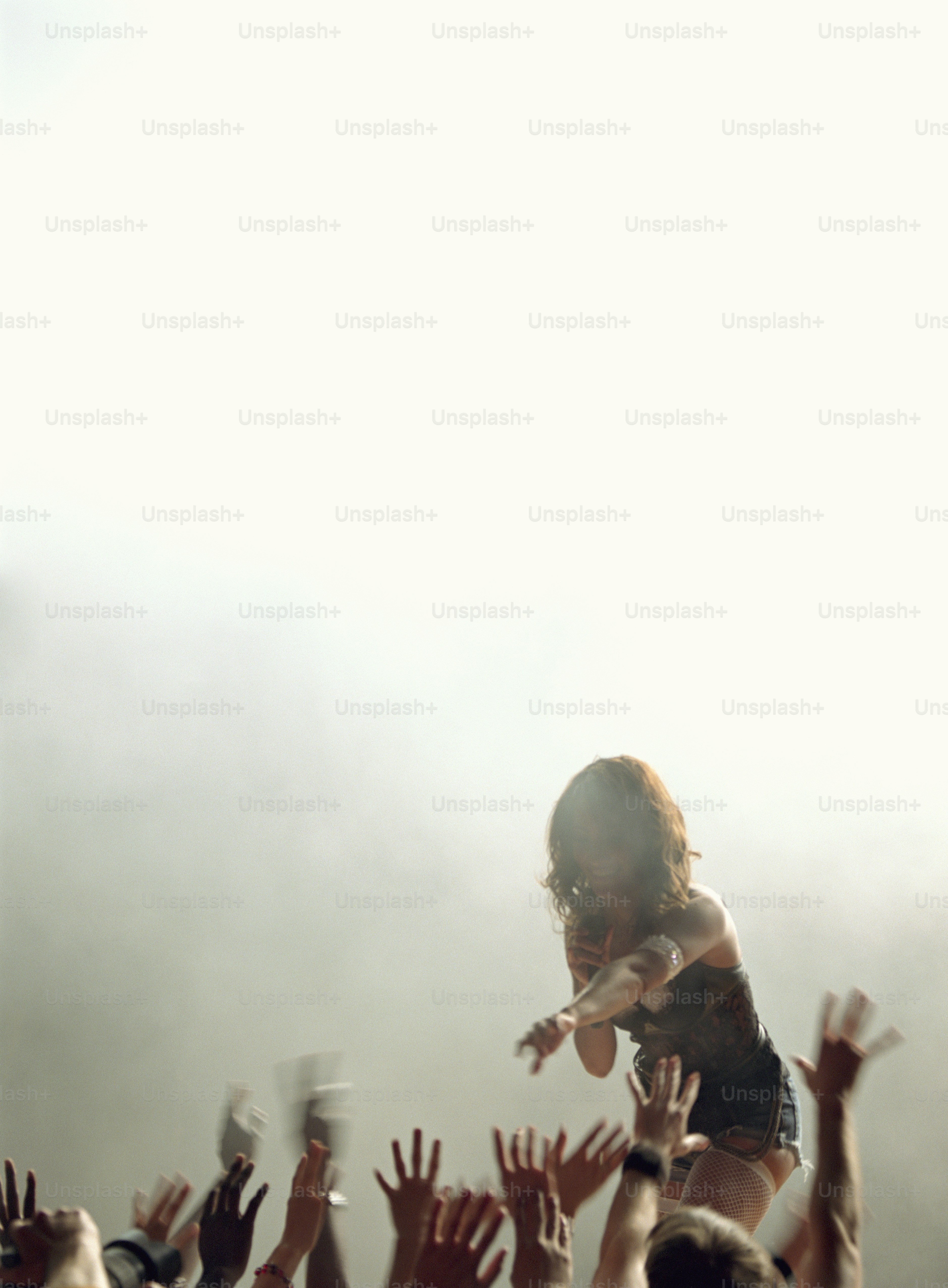 Una persona en un escenario con las manos en el aire