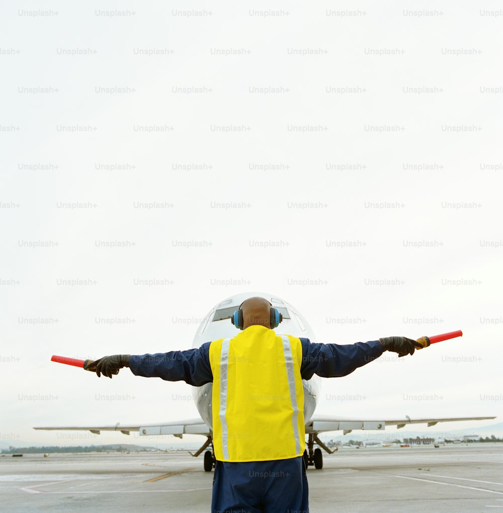 a man standing in front of an airplane on a runway
