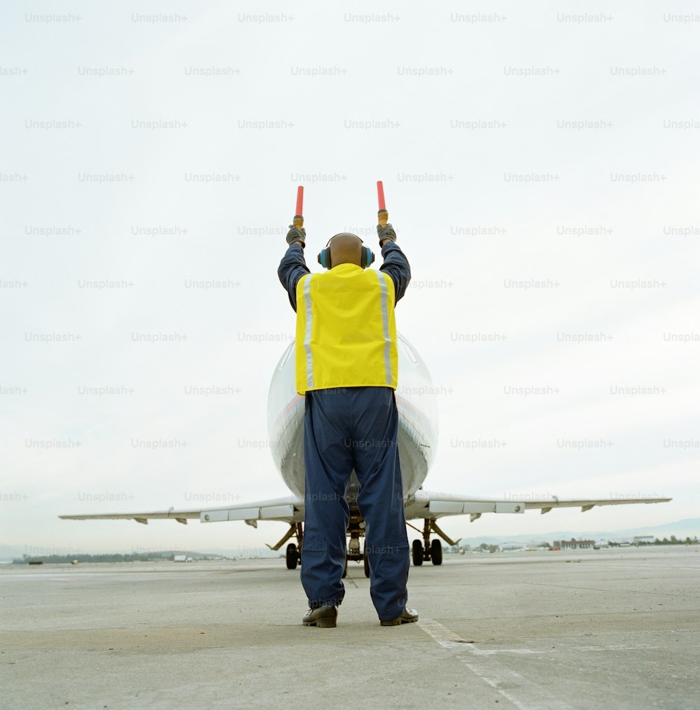 Un homme debout devant un avion sur une piste
