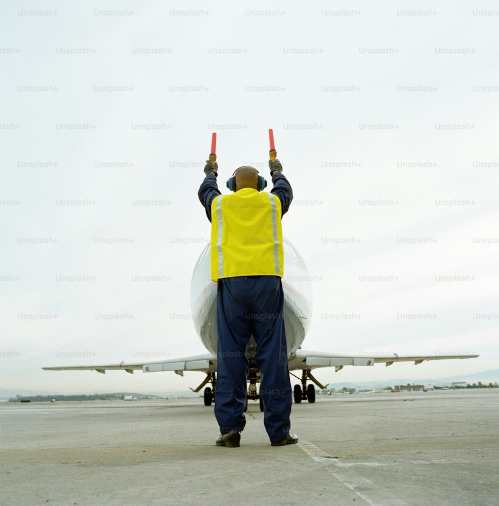a man standing in front of an airplane on a runway