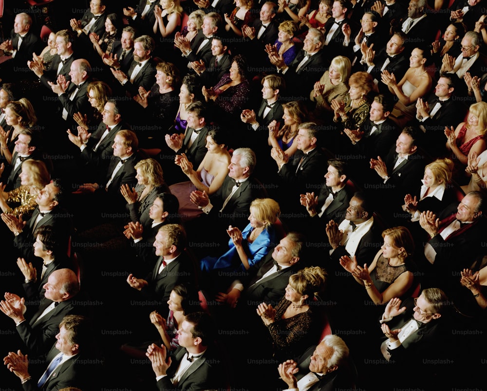 a crowd of people in suits and ties clapping