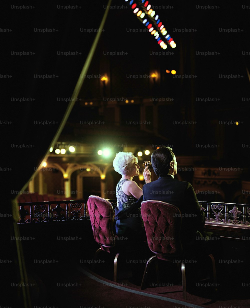 a man and a woman sitting in chairs at a table