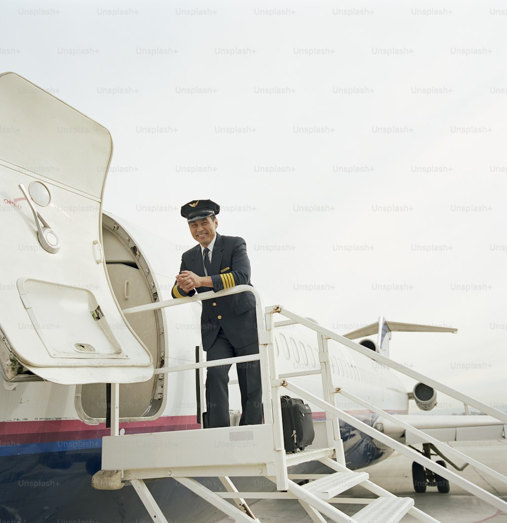 a man in a suit standing on the steps of an airplane