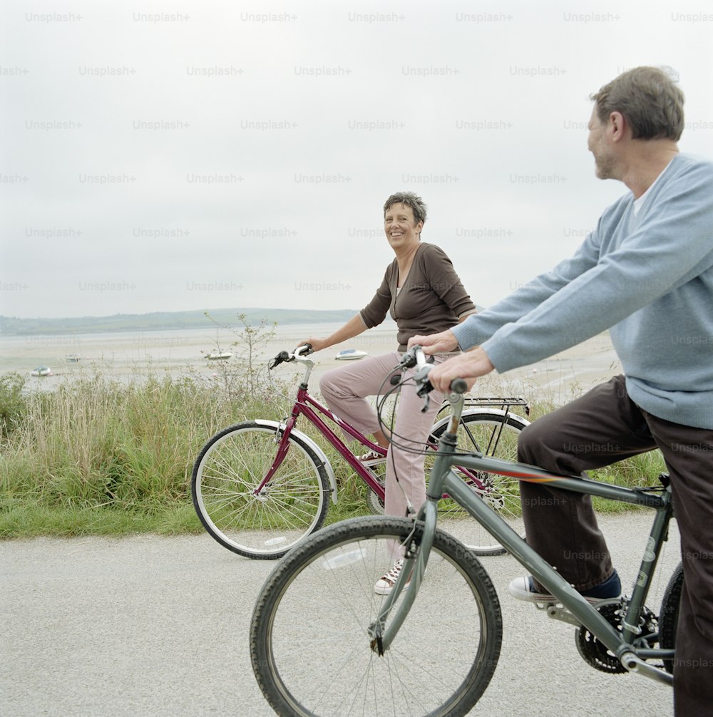 Un hombre y una mujer andando en bicicleta en una carretera