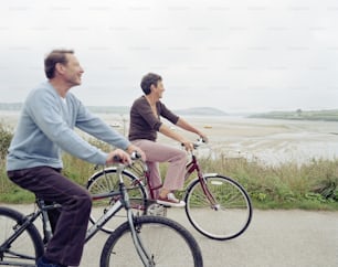 a couple of people riding bikes down a road