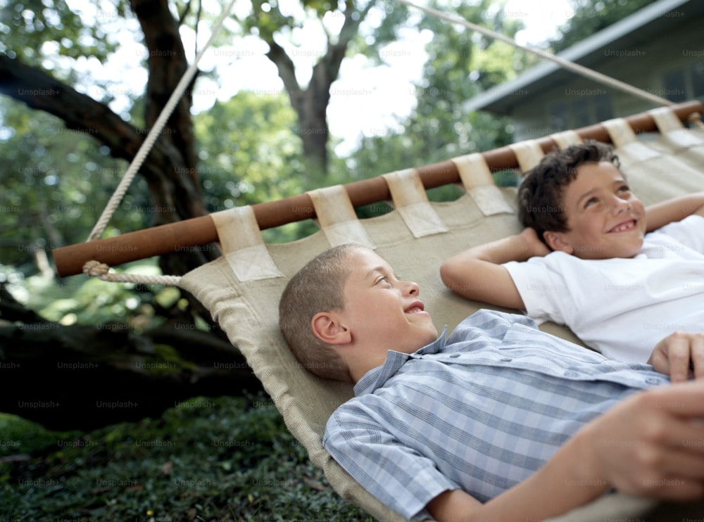 a boy and a boy laying in a hammock