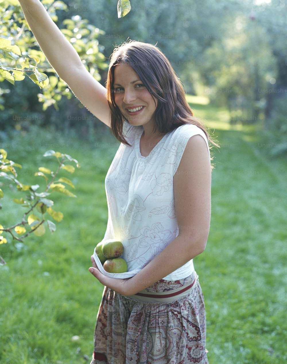 a woman holding a green apple in her hand