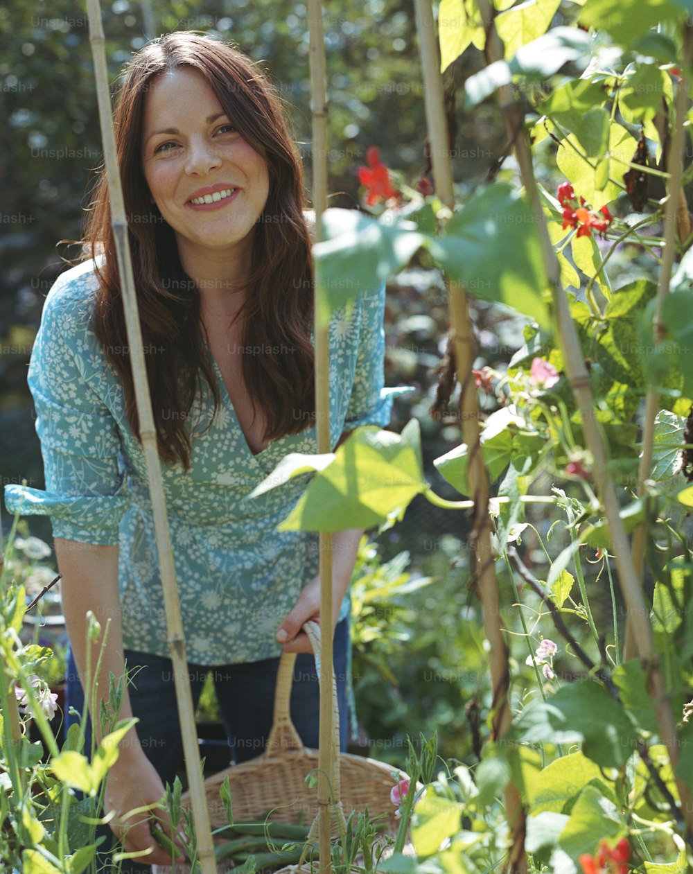 Una donna in piedi in un giardino che tiene un cesto