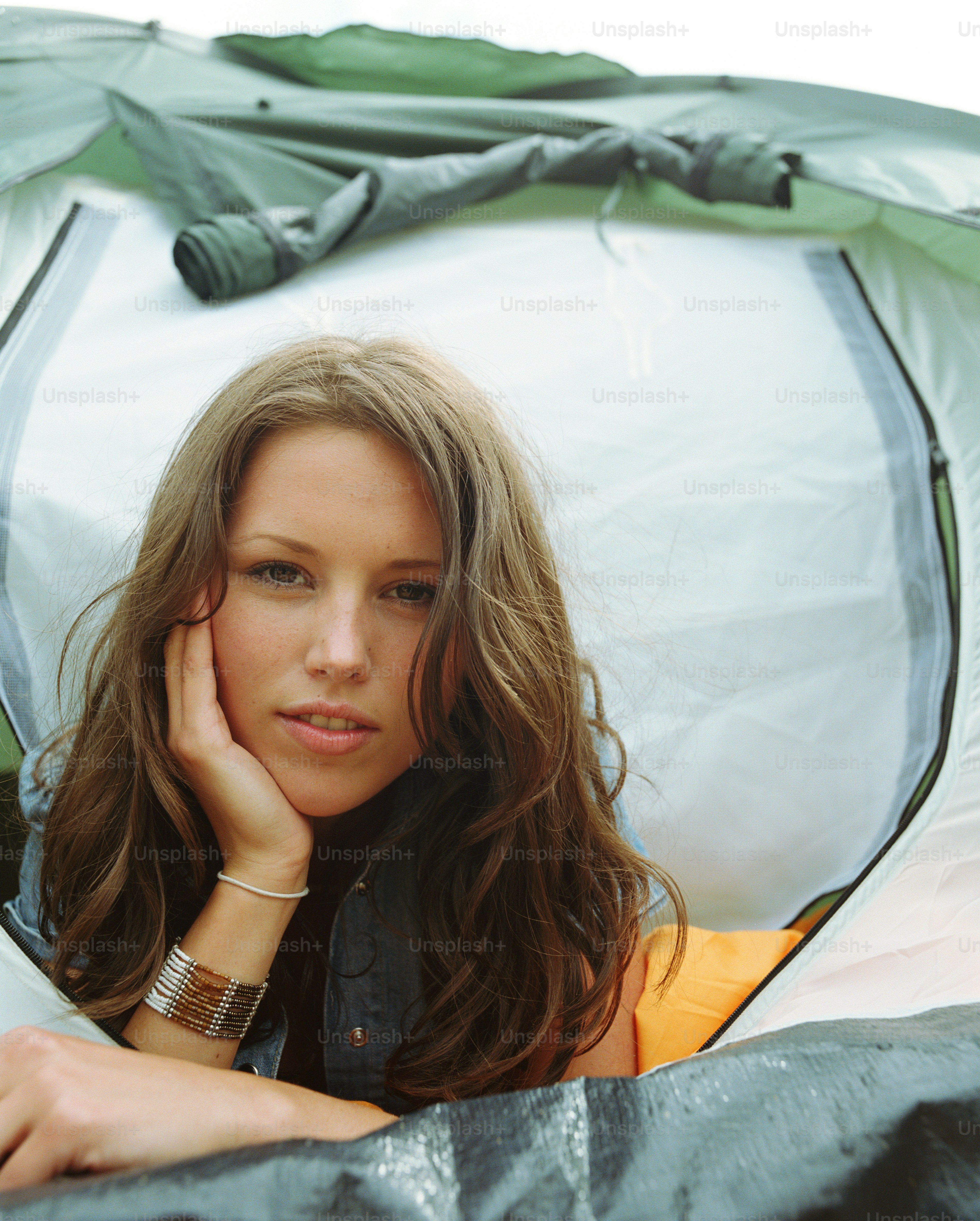 a beautiful young woman laying in a tent