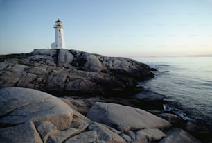 岩だらけの海岸の上に座っている灯台