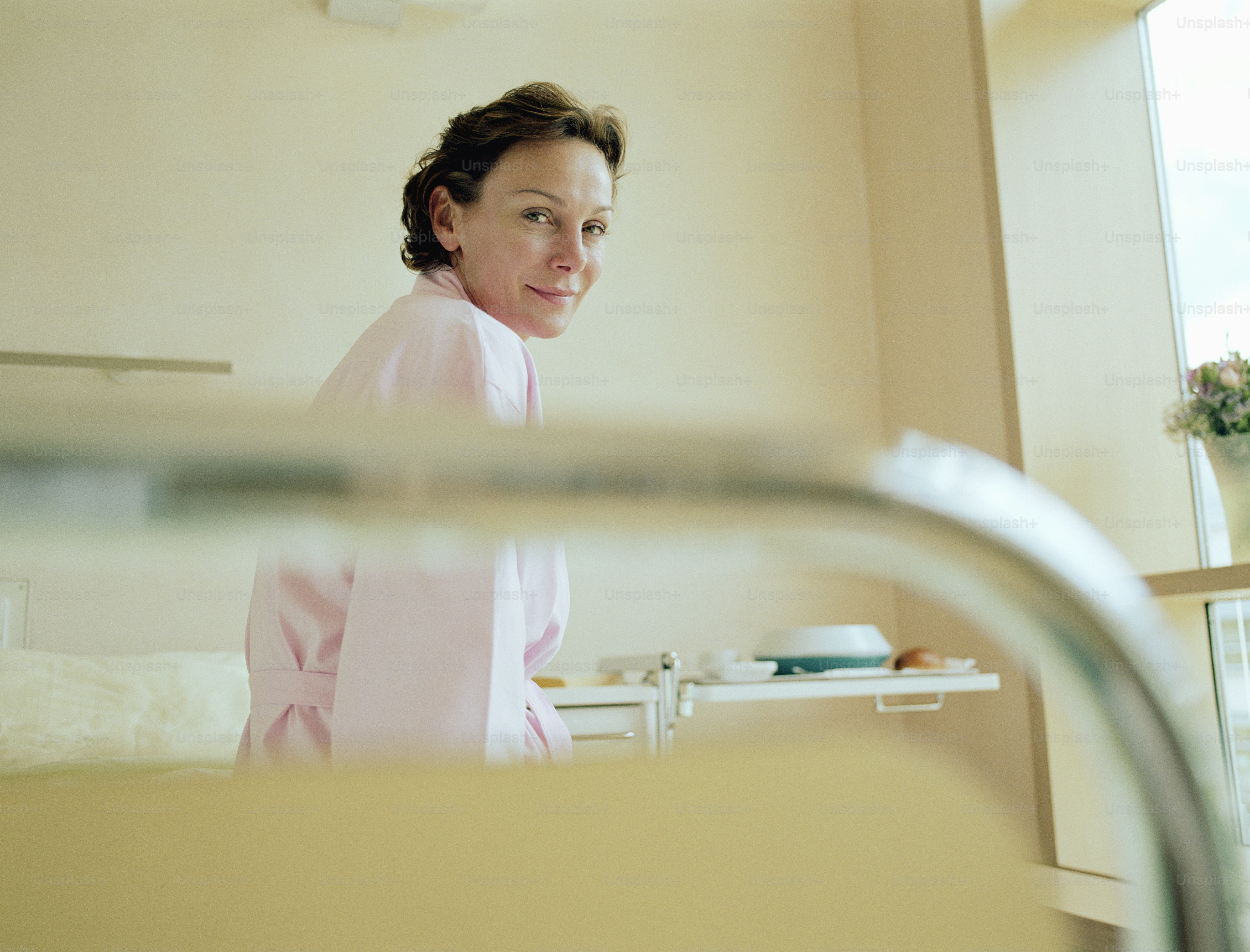 a woman standing in front of a bed in a room