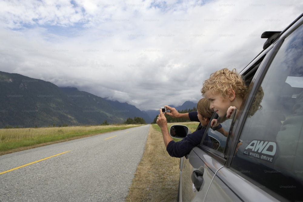 Son (5-7 years) leaning out of rear window.