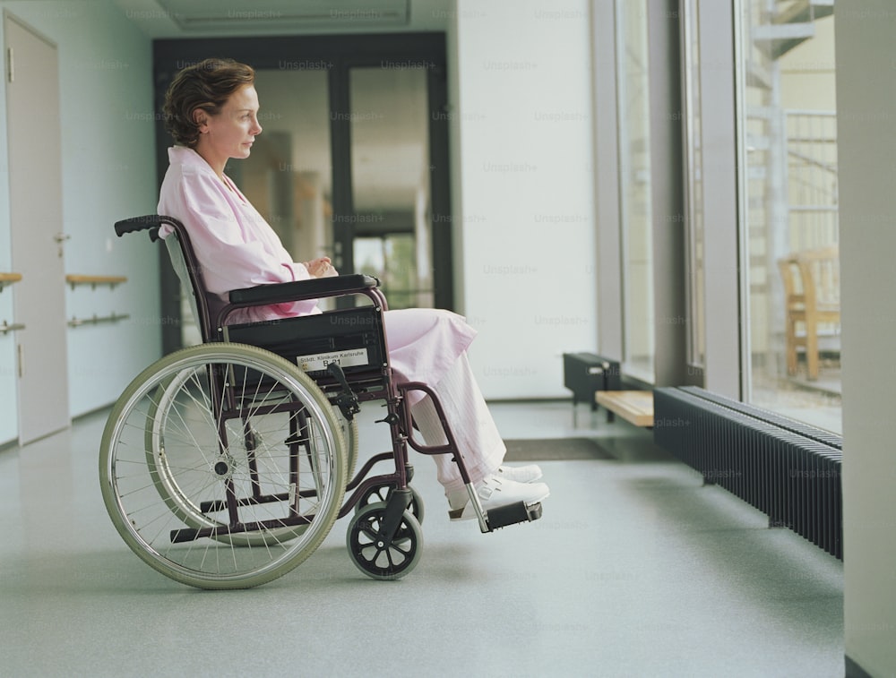 a woman in a wheelchair looking out a window