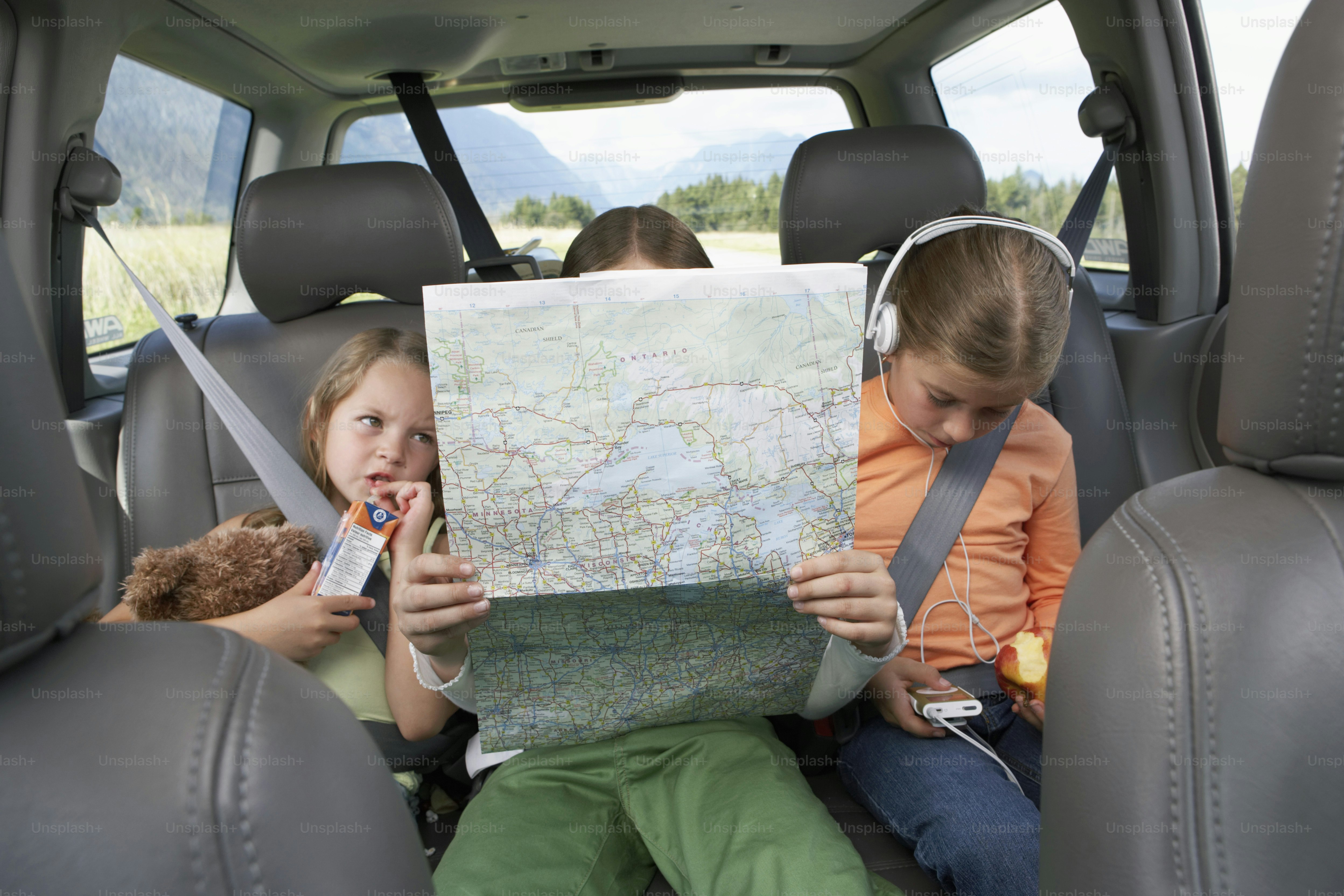 a couple of kids sitting in the back of a car