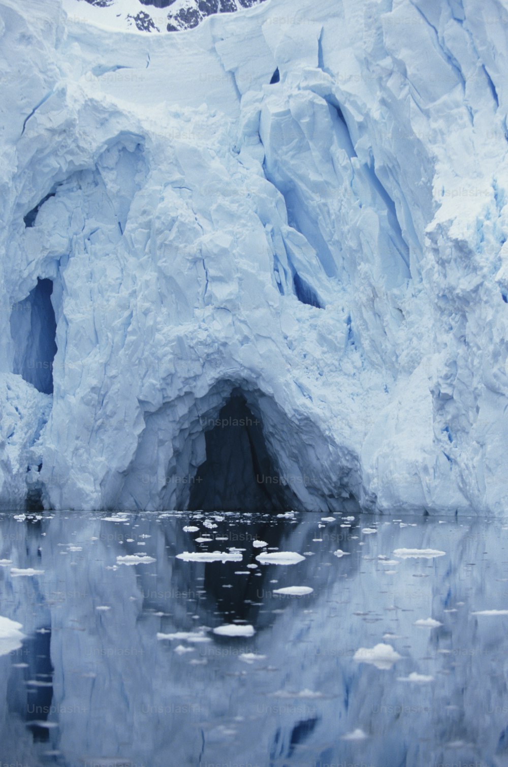 a large iceberg with a reflection in the water