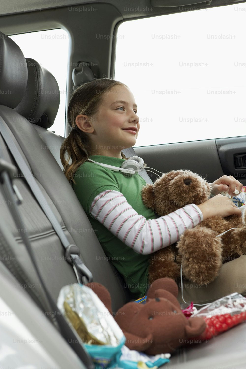 Ein kleines Mädchen, das auf dem Rücksitz eines Autos sitzt