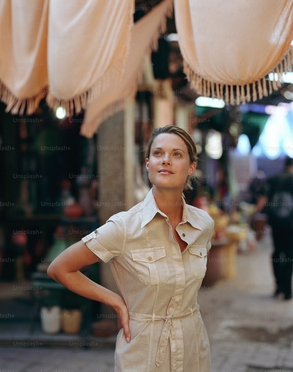 Una donna in piedi di fronte a un negozio con le mani sui fianchi