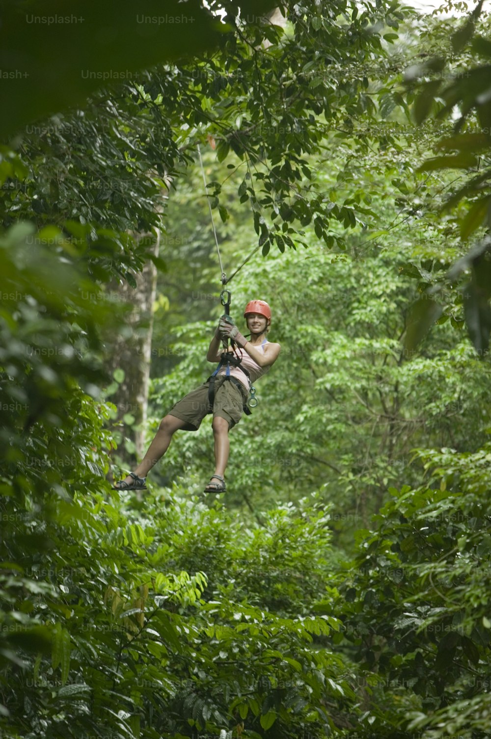 a man is zipping through the trees in the jungle