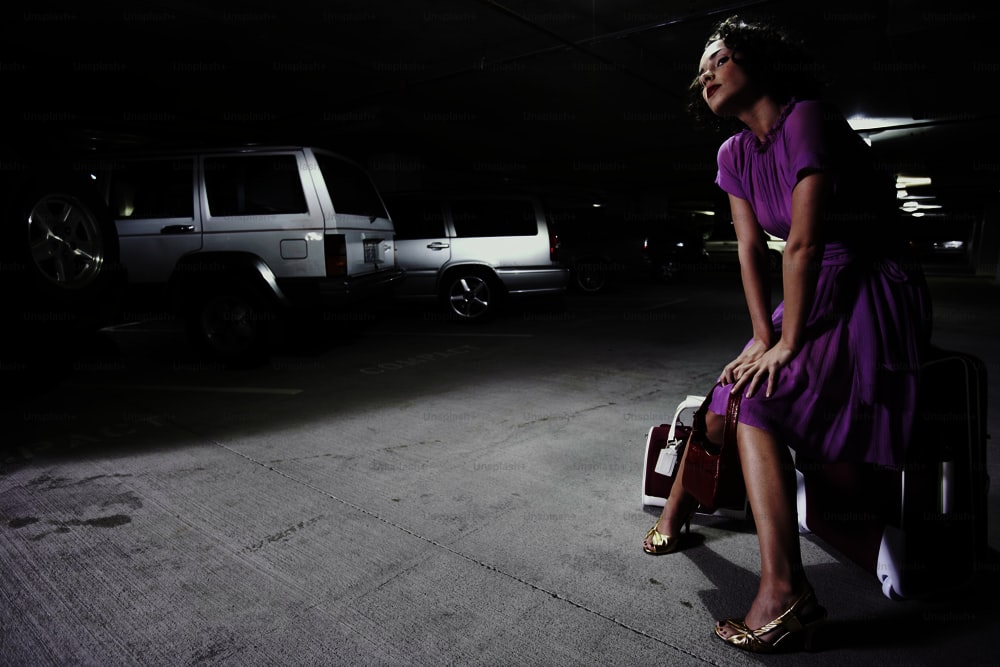 a woman in a parking garage with her luggage