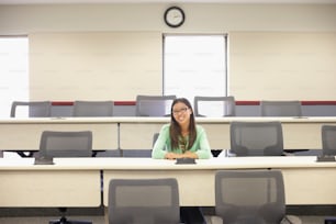 a woman sitting at a desk in a classroom