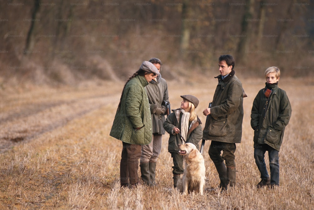 Un gruppo di persone in piedi in un campo con un cane