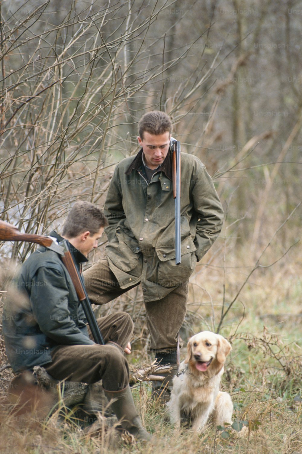 森の中で銃と犬を持つ男
